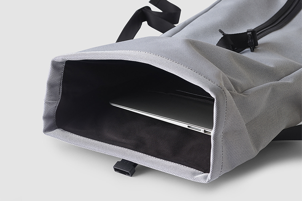 An open gray backpack with a laptop inside.