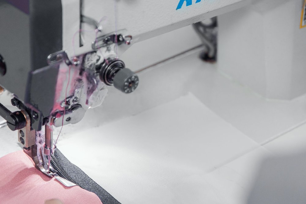 A worker is sewing with a sewing machine.